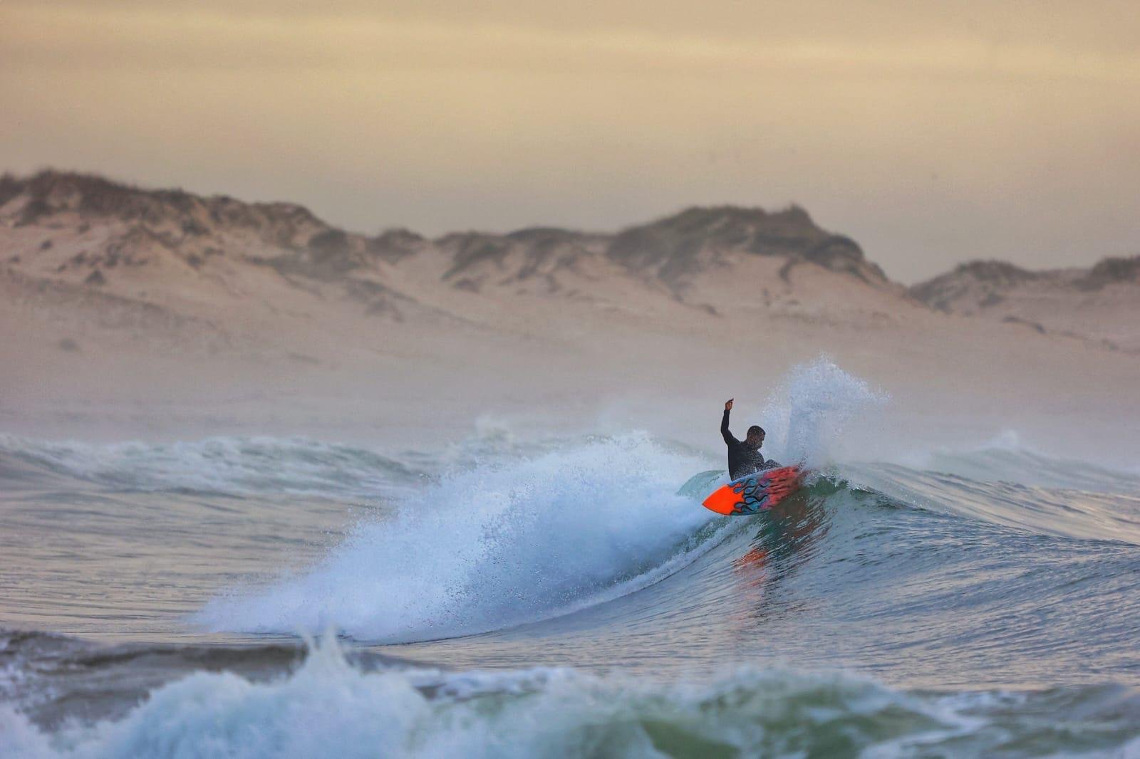 A surfer carving a turn in a wave, spray catching the light